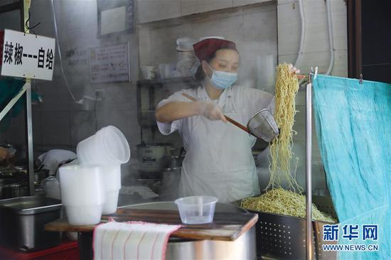 4月22日，武漢市糧道街的家陽“趙師傅”天天紅油熱干面店廚師在制作熱干面。新華社記者 沈伯韓 攝